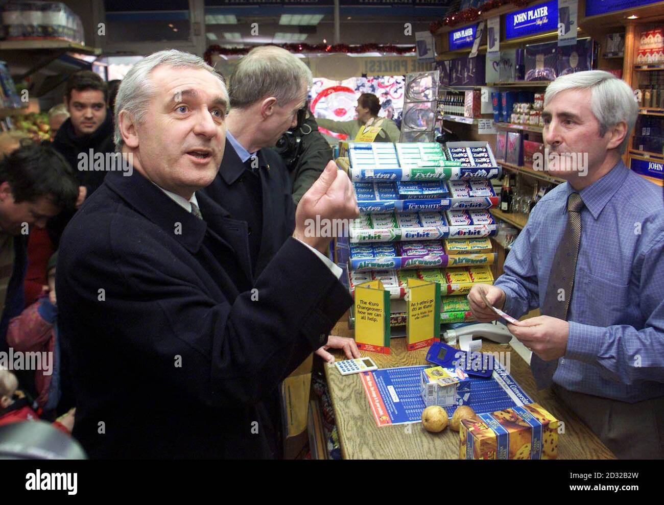 Irish Prime Minister Bertie Ahern makes a purchase from Jim O'Neill, proprietors of O'Neill's the local newsagents, with the new Euro currency. Queues formed outside the Irish Central Bank in Dublin to receive supplies of Euro notes.   * Notes only became officially available from midnight, and although Irish businesses were handed reserves in advance, members of the public had to wait until the first cash machines opened at around 6am after being re-programmed and having their punts stocks replaced with Euros. Stock Photo