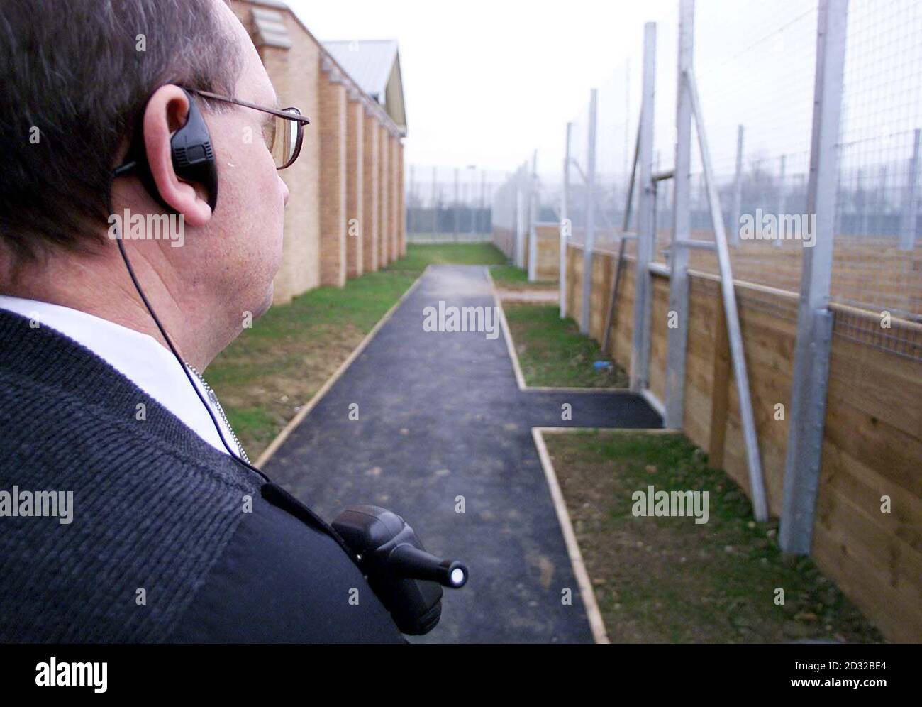 A security guard surveys the boundaries of Yarl's Wood, Europe's largest detention centre for asylum seekers which was unveiled. The massive facility is on a former Ministry of Defence base near Bedford. * .... and forms part of Home Secretary David Blunkett's pledge to remove 30,000 failed asylum seekers from the country a year. Yarl's Wood, which is thought to have cost 100 million to build, will hold 900 detainees who have exhausted their attempts to win asylum in the UK, plus other immigration offenders. Stock Photo