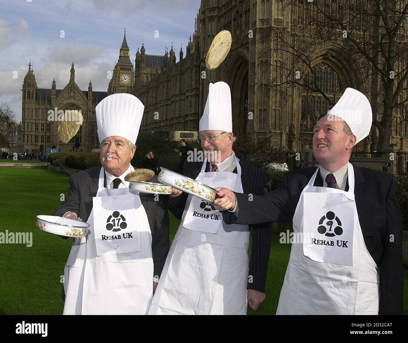 Lord Morris of Manchester (left), Brian Iddon, MP for Bolton and Sale East and Paul Goggins MP for Wythenshawe (left) take part in the annual Shrove Tuesday Parliamentary pancake race on the green opposite the House of Lords in Westminster, London.   *  The event, in aid of brain injury charity Rehab UK, involves a team of MPs and a team from the Lords donning tall chefs' hats and whites and racing each other while tossing pancakes three feet into the air. Stock Photo