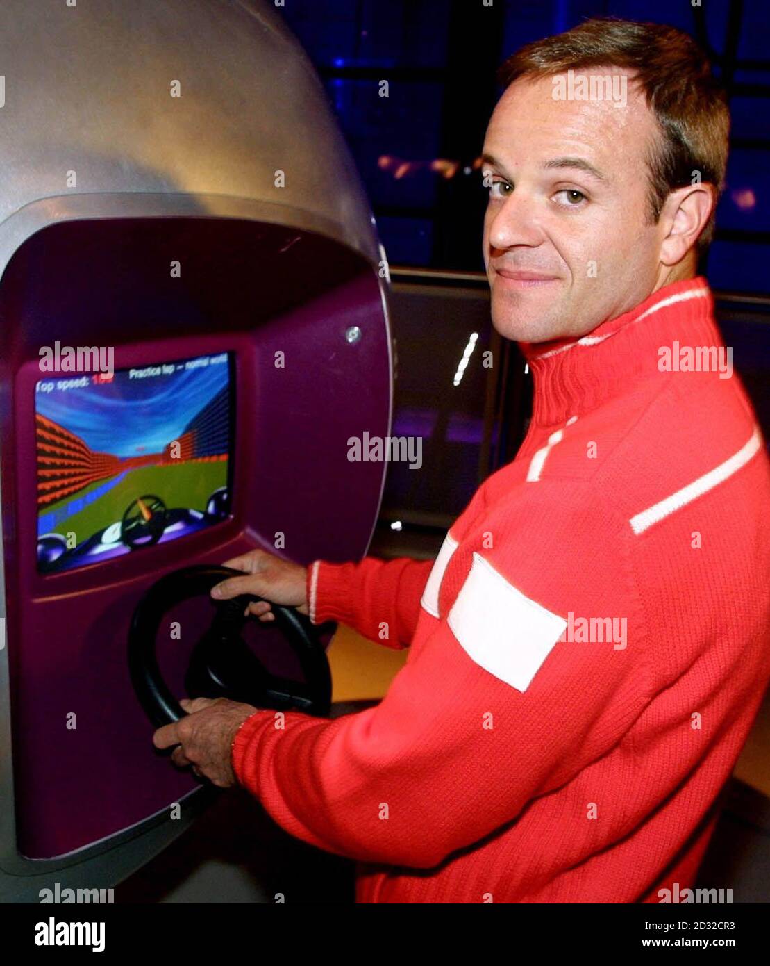 Ferrari Formula One racing driver Rubens Barrichello tries his skills on a computer driving game during a visit to the Alfa Romeo: Sustaining Beauty-90 years of art in engineering, at the Science Museum in London. Stock Photo