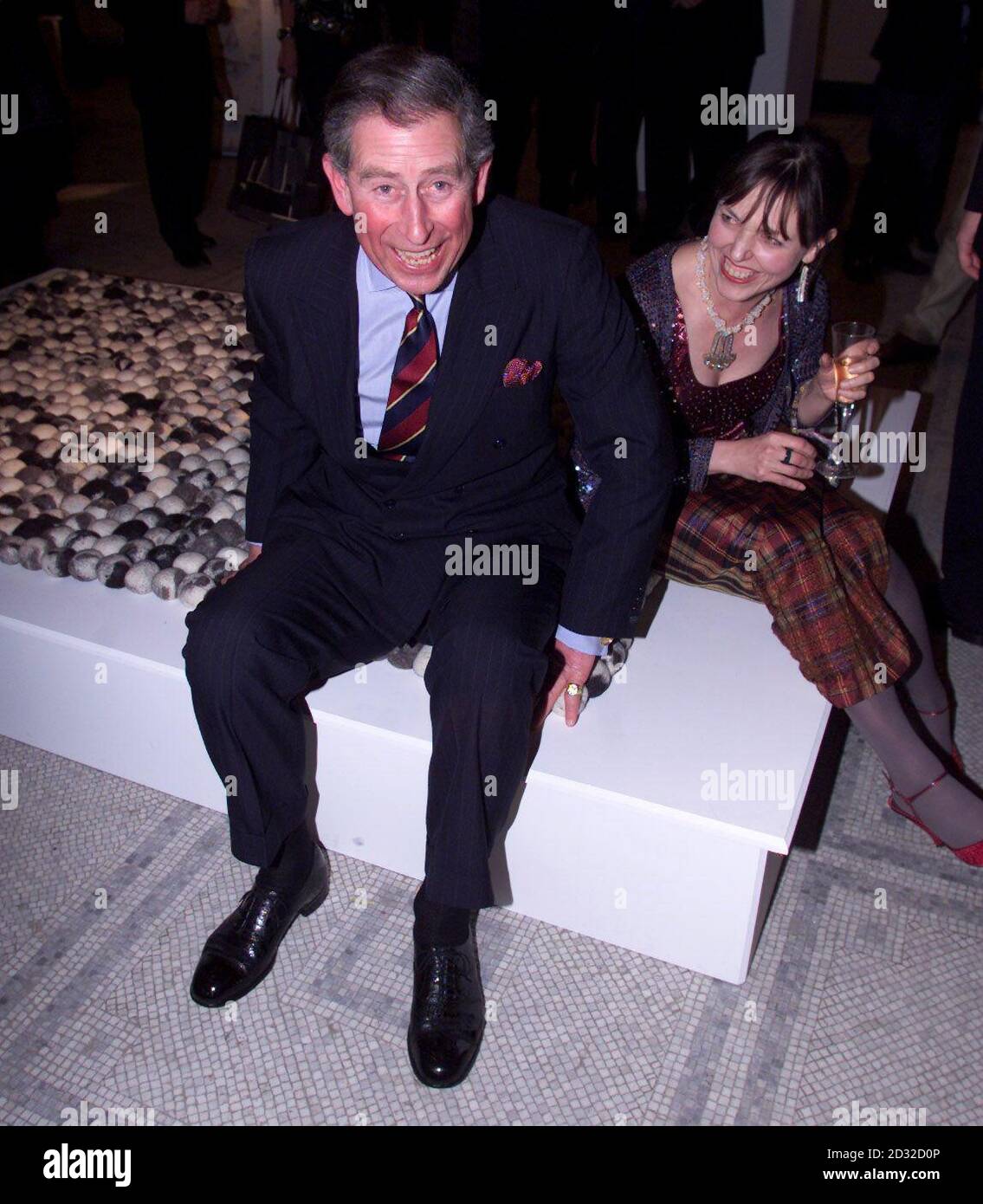 The Prince of Wales sitting on a wool cobble rug with it's designer Annie Sherbourne, at the Homes and Gardens designs awards at the Victoria and Albert Museum in London. Stock Photo
