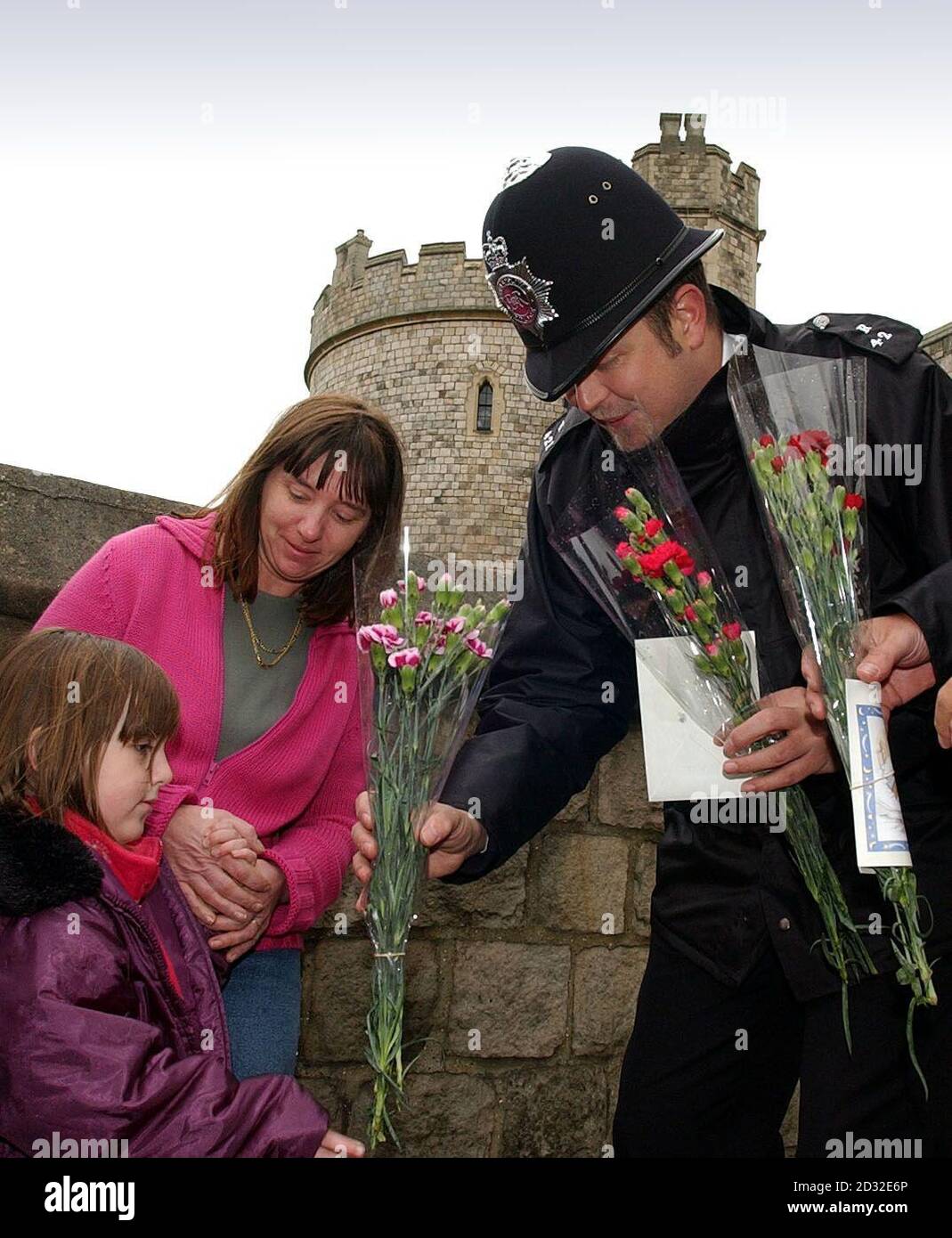 A family arrives at Windsor Castle, Berkshire to lay flowers in memory