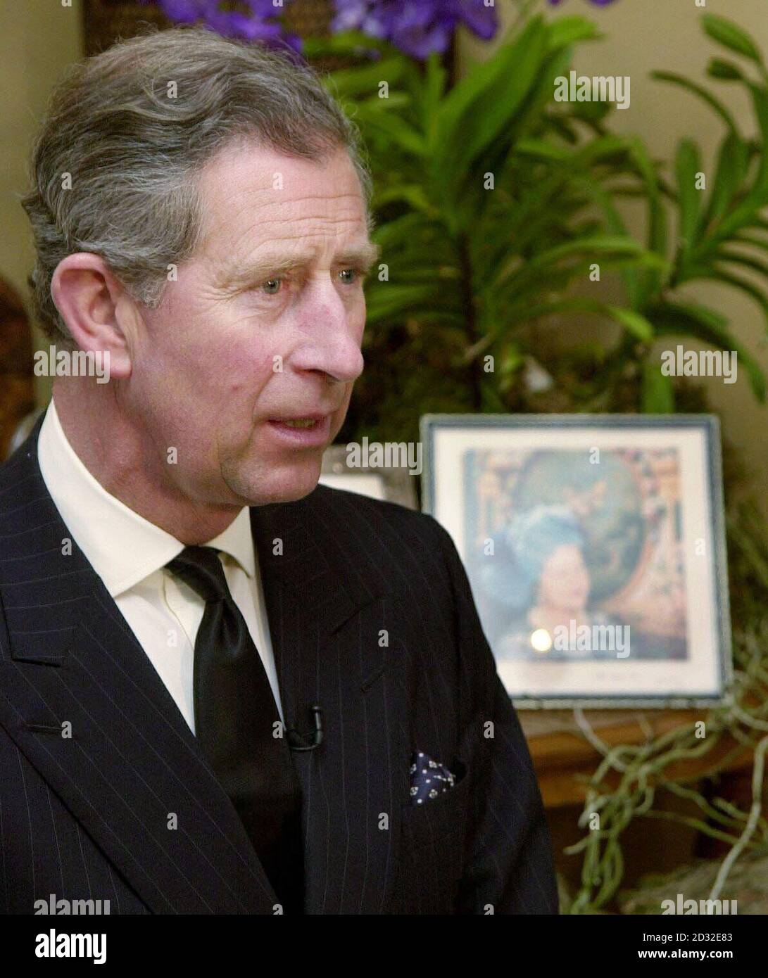 The Prince of Wales at his Highgrove home from where he paid a tribute to his 'darling grandmother', Queen Elizabeth the Queen Mother who died Saturday aged 101. The Prince, wearing a dark suit and black tie, was seated in the Orchard Room.  *... in an outbuilding of his Gloucestershire residence, with two framed photographs of the Queen Mother on a table behind him. Stock Photo