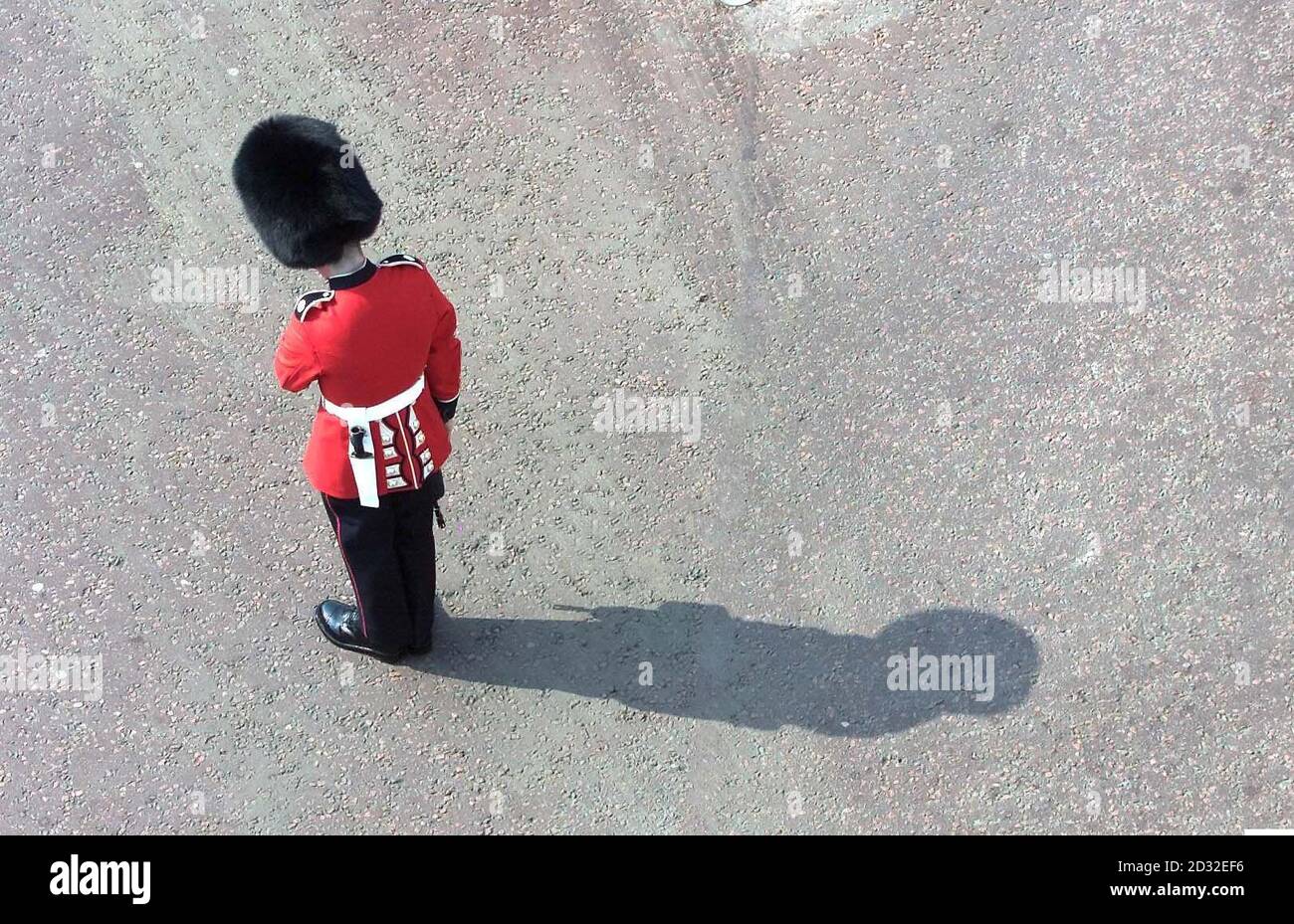 A soldier with the Coldstream Guards stands still on the Mall as the coffin of Queen Elizabeth, the Queen Mother, passes on its way to Westminster Hall, where she will lie-in-state until her funeral at Westminster Abbey.  Stock Photo