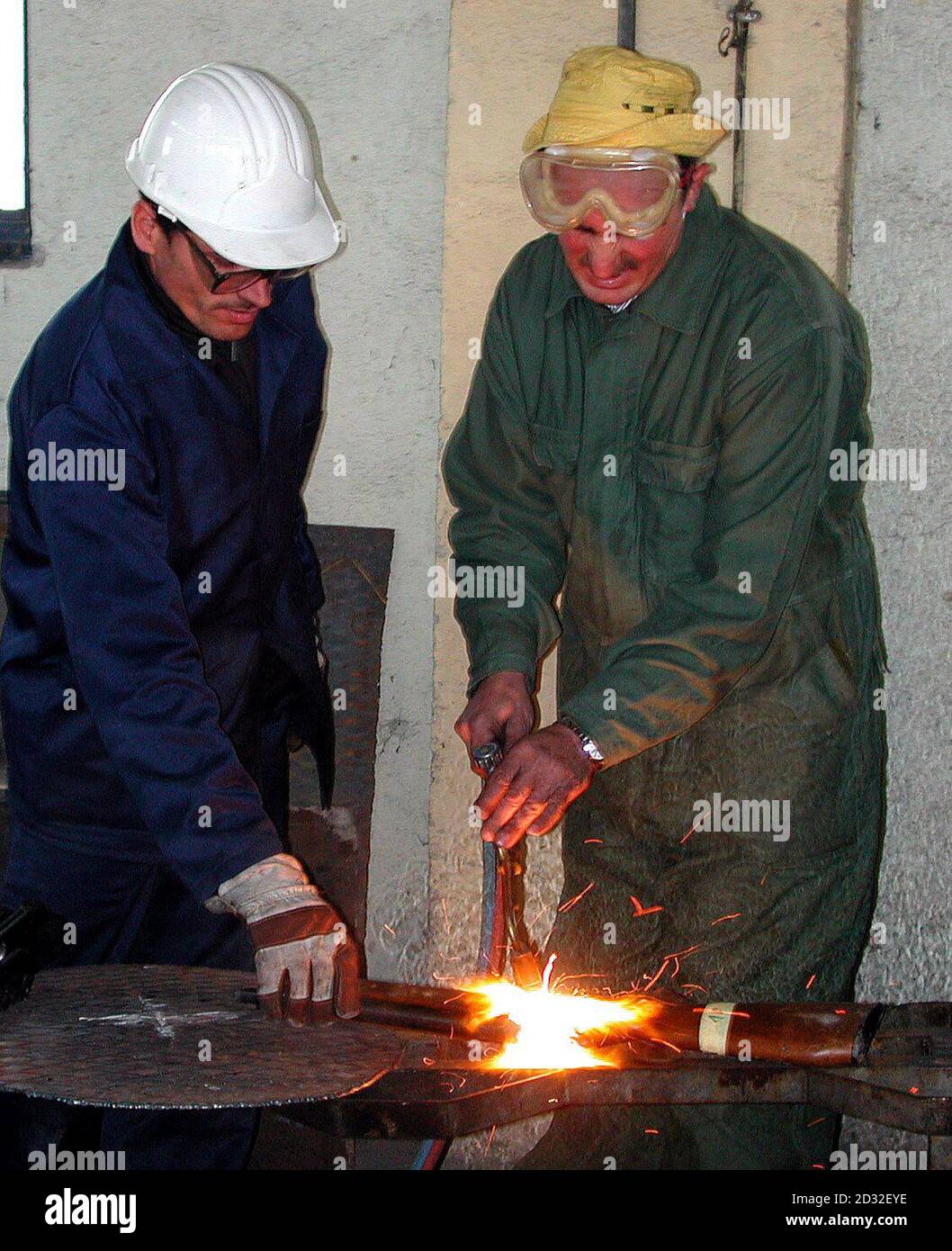 Workers cut up a rifle, at a weapons destruction centre in Janjevo, Kosovo, which was handed in as part of an amnesty which is being policed by British troops as part of KFOR. Stock Photo