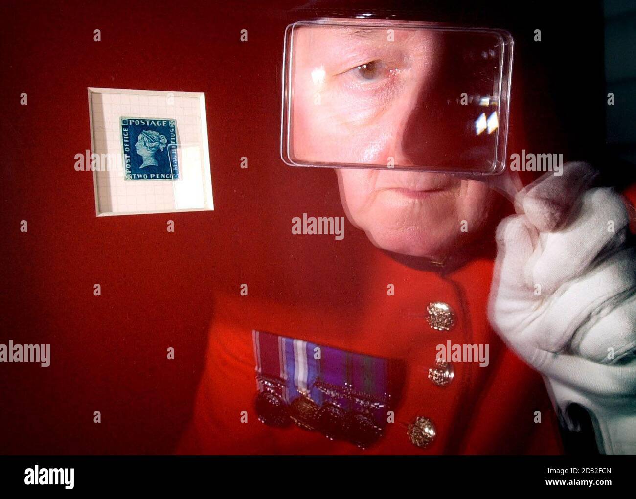 Chelsea pensioner Charlie Liddle, 68, from Leith, inspects an extremely rare 1847 Twopenny Blue stamp from Mauritius known as 'The Blue Mauritius', at the opening of the travelling 'Royal Philatelic Collection' at Holyroodhouse in Edinburgh. * The exhibition of the Collection, which belongs to the Royal Family, is the first public showing and forms part of the 2002 Jubilee celebrations. Stock Photo