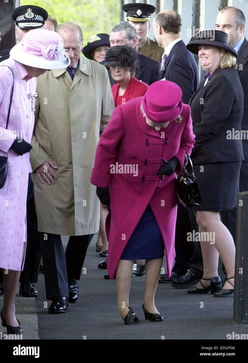 Britain's Queen Elizabeth II examines the sole of her shoe as she is accompanied by the Duke of Edinburgh and the Lord Lieutenant of Cornwall Lady Mary Holborow (left) on the railway station platform at Falmouth on the first day of her nationwide Golden Jubilee tour. *... which is starting with a two-day visit to the West Country. In the coming weeks, the 76-year-old monarch will visit every region of England, Scotland, Wales and Northern Ireland. Stock Photo