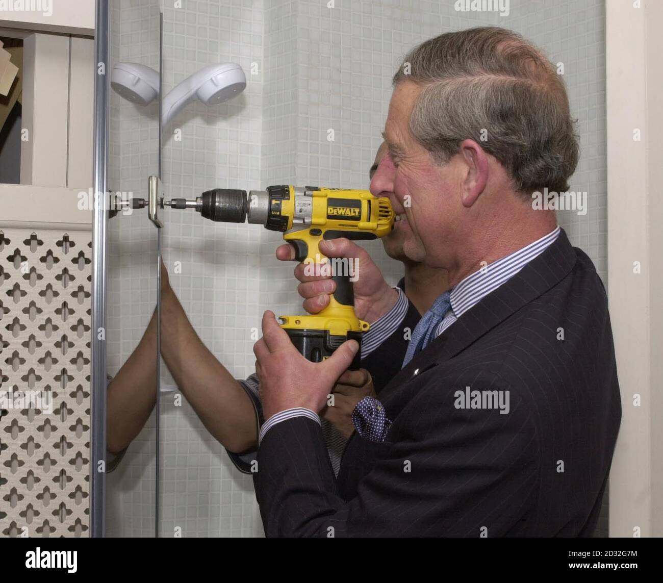 The Prince of Wales puts the finishing touches during a visit to see Mr Steven Puleston - the 50,000th recipient of the a Prince's Trust Grant - as he put the finishing touches to his latest building work in Primrose Hill, north London. Stock Photo