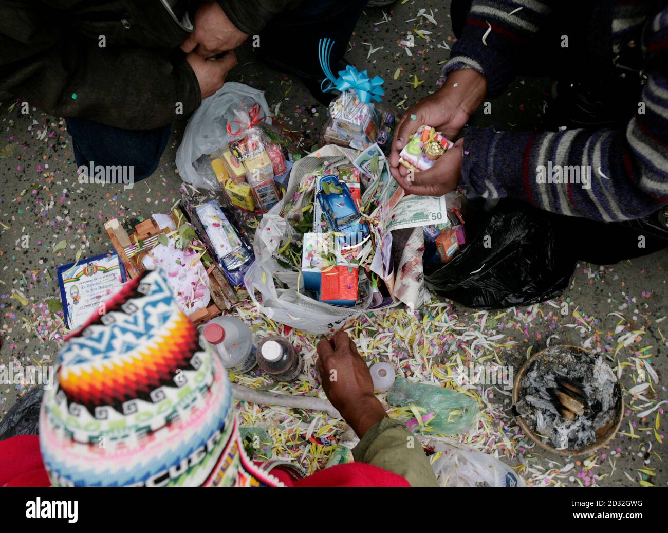 A Bolivian Indian witchdoctor (bottom) blesses the goods of a couple during the traditional 'Alasitas' fair in La Paz January 24, 2010. During this fair, Bolivians buy miniature versions of goods like cars, money and houses they would like to own in real life during the year.  REUTERS/Mariana Bazo (BOLIVIA - Tags: SOCIETY) Stock Photo