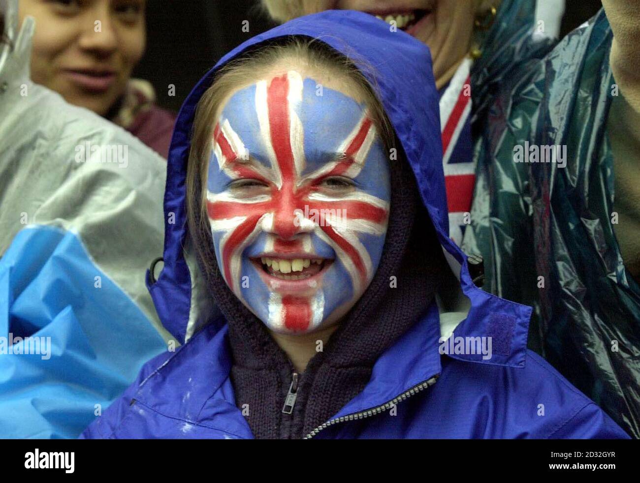 A young spectator with the Union Jack painted on her face waits with early morning spectators to see Britain's Queen Elizabeth II outside Buckingham Palace.   * The Queen and the Duke of Edinburgh will leave Buckingham Palace in a State Gold Coach for a thanksgiving service at St Paul's Cathedral, before returning to watch a parade in The Mall on the final day of the Golden Jubilee. Stock Photo