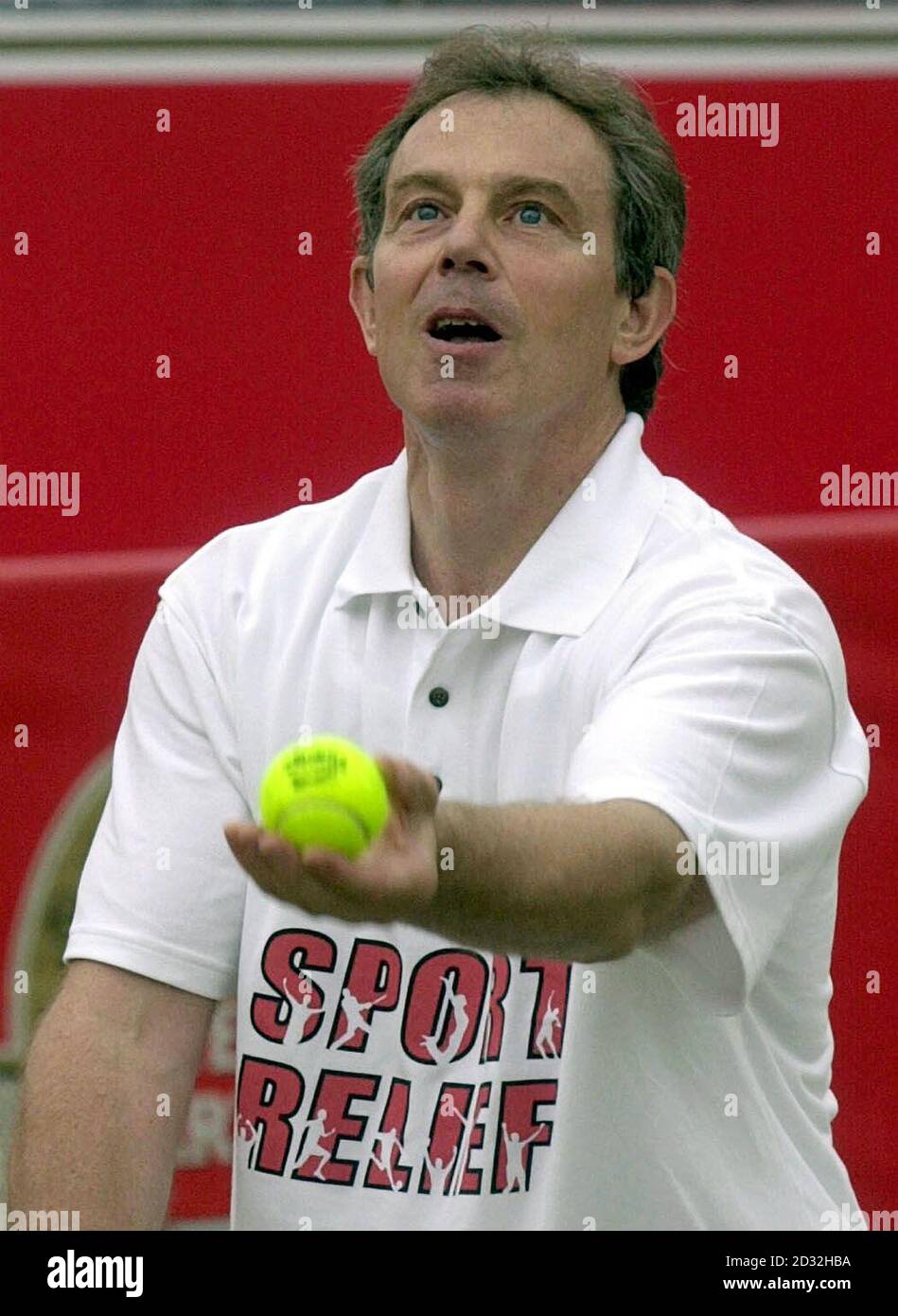British Prime Minister Tony Blair serving the ball during a tennis match for sport Relief at the Stella Artois Championships in Queen's Club, London. *... Tony Blair and former Wimbledon Champion Pat Cash defeated Ilie Nastase and Impressionist Alistair McGowan 4 games to 1. Stock Photo