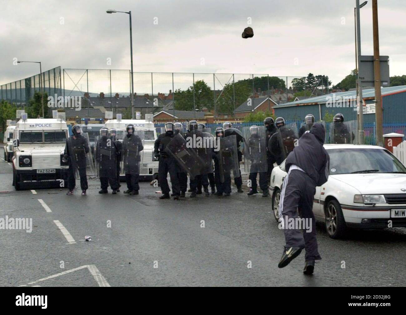 A Catholic youth throws a rock at police on the Springfield Road, west Belfast. Police suffered a barrage of petrol bombs, fireworks, and bricks after officers fired a plastic baton rounds at protesters attacking an Orange Order parade in a Nationalist area.   * The trouble began when Catholic protesters saw Orangemen walking up a contested part of the Springfield Road.  Stock Photo