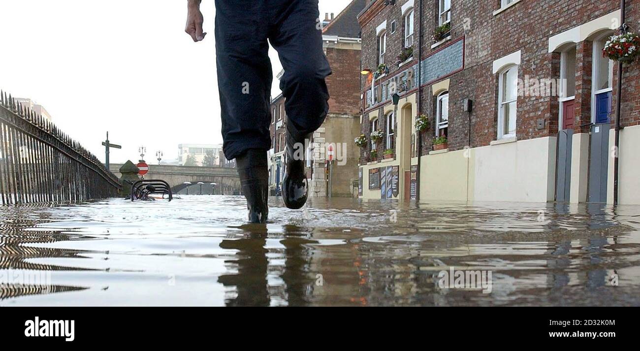 A man wades through a flooded street in the city of York. Stock Photo
