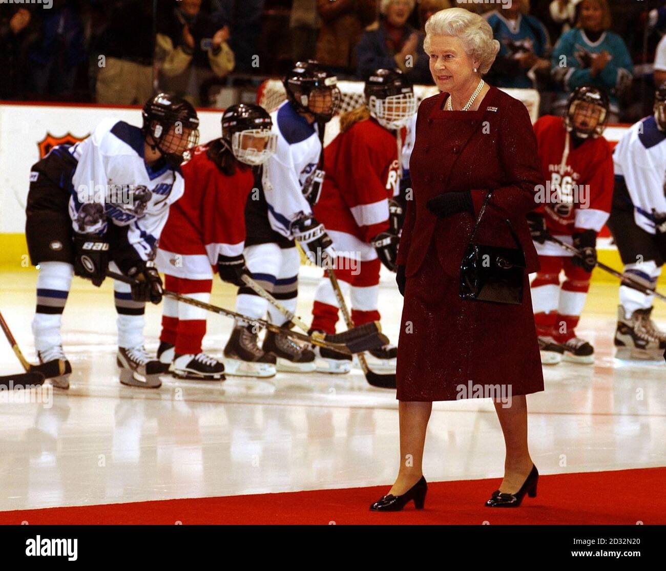 Britain's Queen Elizabeth II walks onto the ice rink on a red carpet before she starts an ice hockey game between San Jose Sharks and Vancouver Canucks in Vancouver, Canada, during her two week Golden Jubilee tour of the country.  *...The Queen, and her husband, the Duke of Edinburgh, went to church at Christ Church Cathedral in Victoria followed by lunch at the Fairmont Empress Hotel where the royal couple were greeted by the Pipes and Drums of the Canadian Scottish Regiment.   Stock Photo