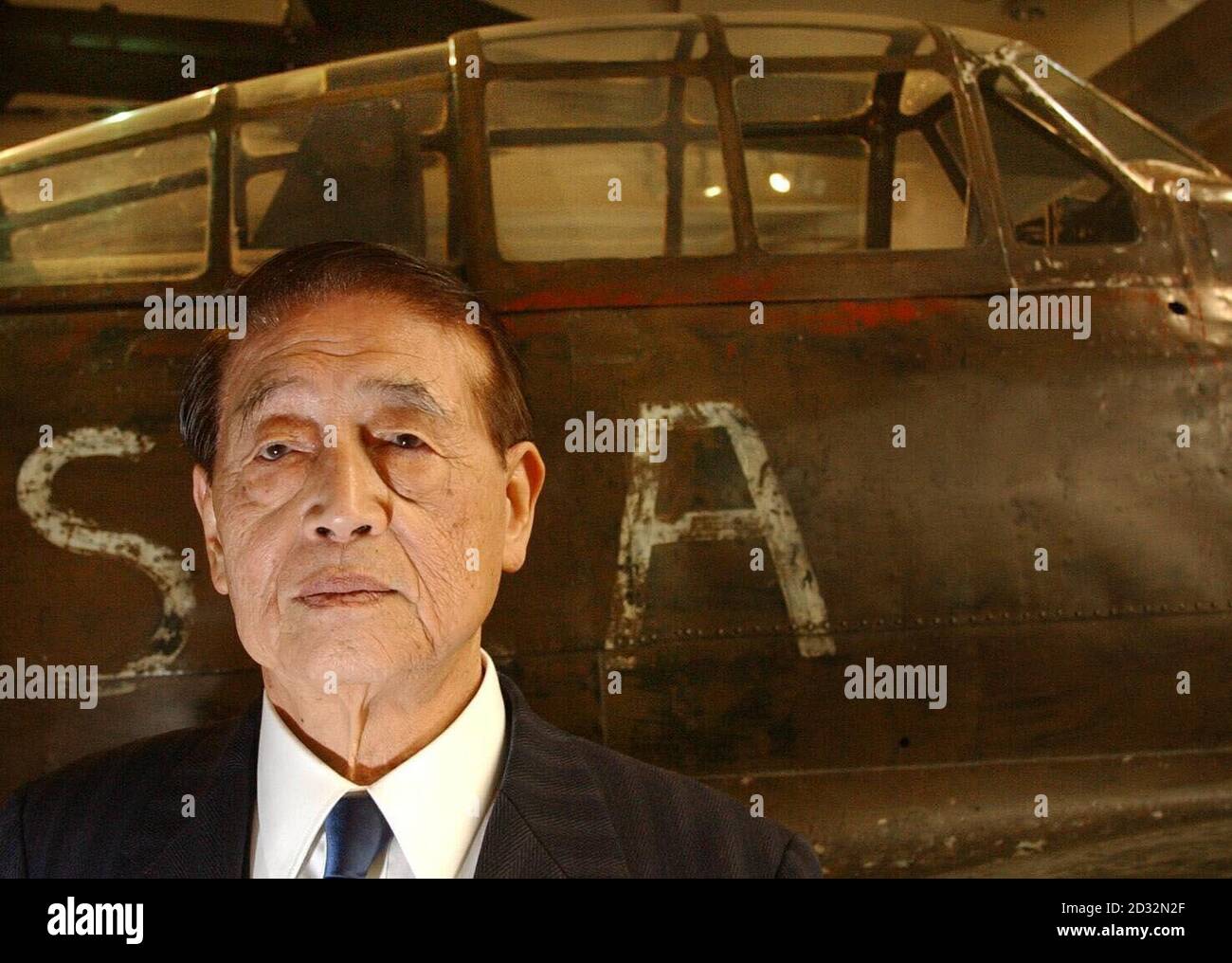 Hichiro Naemura, 82, an ex-Kamikaze pilot in the Japanese Air Force in the Second World War, stands in front of a 'Zero' fighter plane at the Imperial War Museum.   *...Hichiro Naemura was one of only a few surviving airmen from the conflict in the Pacific, which saw thousands of young Japanese men kill themselves in officially sanctioned suicide attacks on allied warships. He was in London to help launch Kamikaze: Japan's Suicide Gods, a new book in which his story is told. Stock Photo