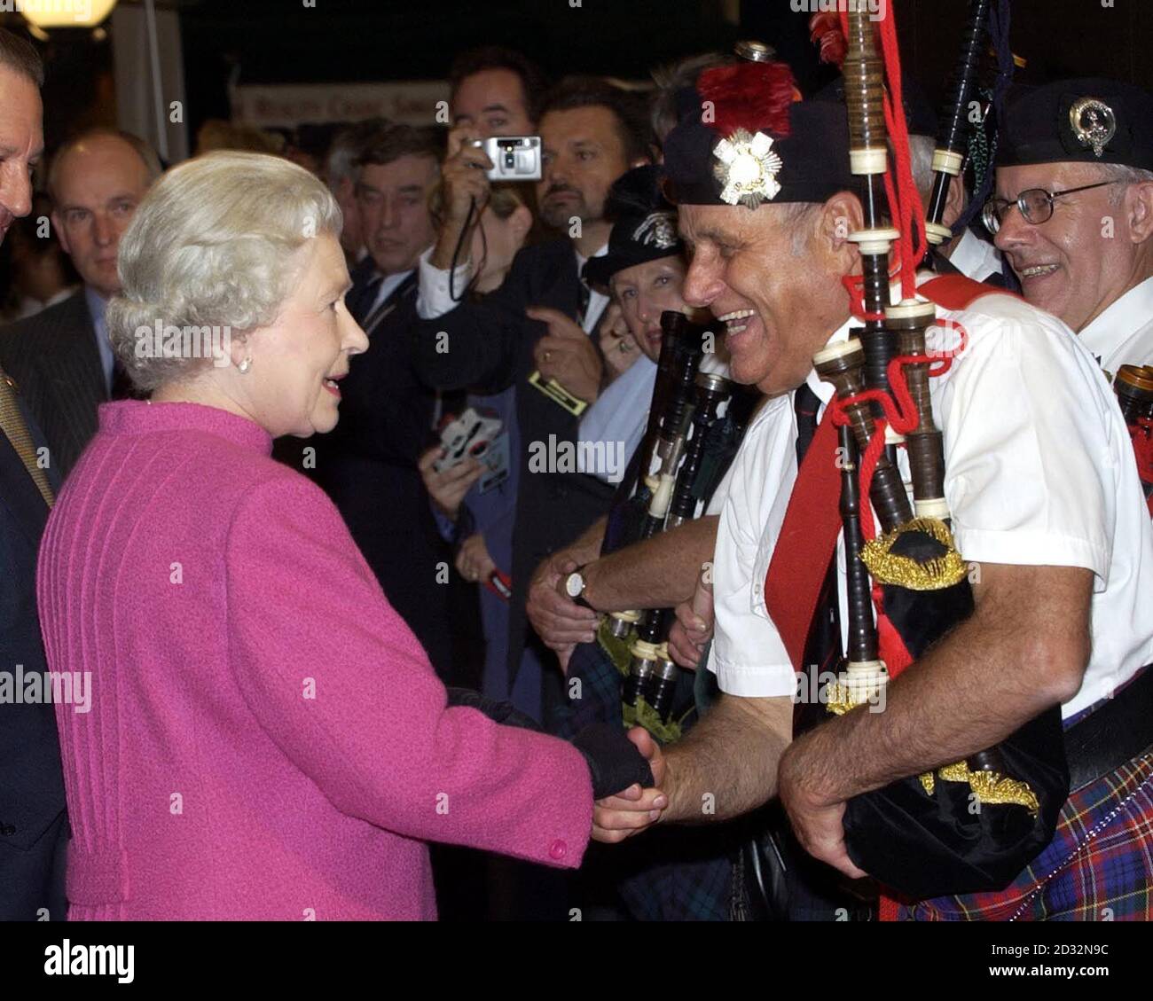 Queen Elizabeth II meets a bagpipe player during a visit to the