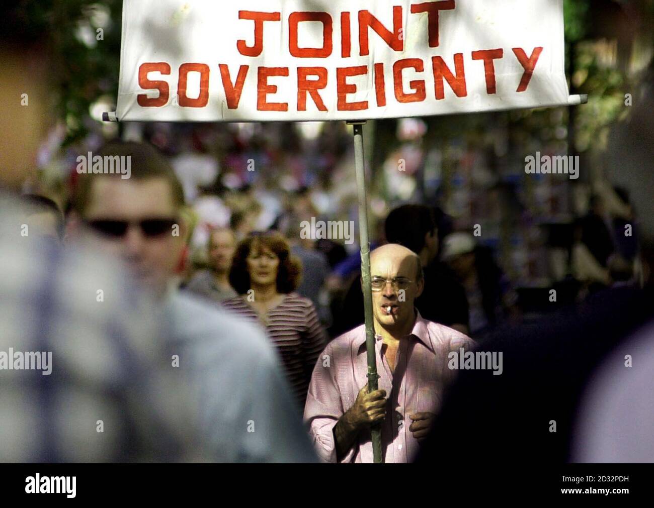 A Gibraltarian holds a 'No To Joint Sovereignty' banner in the centre of the British enclave, urging voters to reject a proposal for a power-sharing deal with Spain in a referendum on the issue .    *.. The concept was first suggested by Foreign Secretary Jack Straw earlier this year, but inhabitants were expected to vote heavily in favour of retaining their British status. Stock Photo