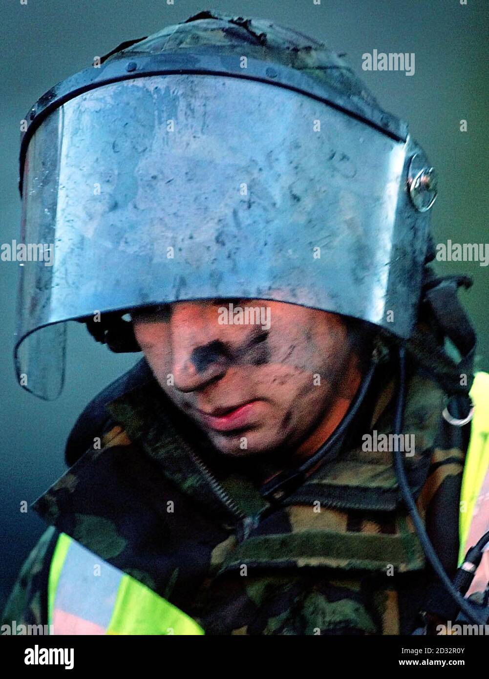 A tired looking Army Green Goddess crew member during damping down at the scene of the fire, early morning in Rochdale, Lancashire. More than 70 military firefighters were called out yesterday to tackle a blaze at a tyre warehouse. * Nine Green Goddesses, one Red Goddess and two Breathing Apparatus Rescue Tenders were sent to the scene. The national fire service are currently serving an eight day strike over pay disputes. 02/12/02 : A 15-page dossier prepared by the Government's emergencies committee, Cobra, praises the 19,000 troops who provided emergency cover during last weeks firefight Stock Photo