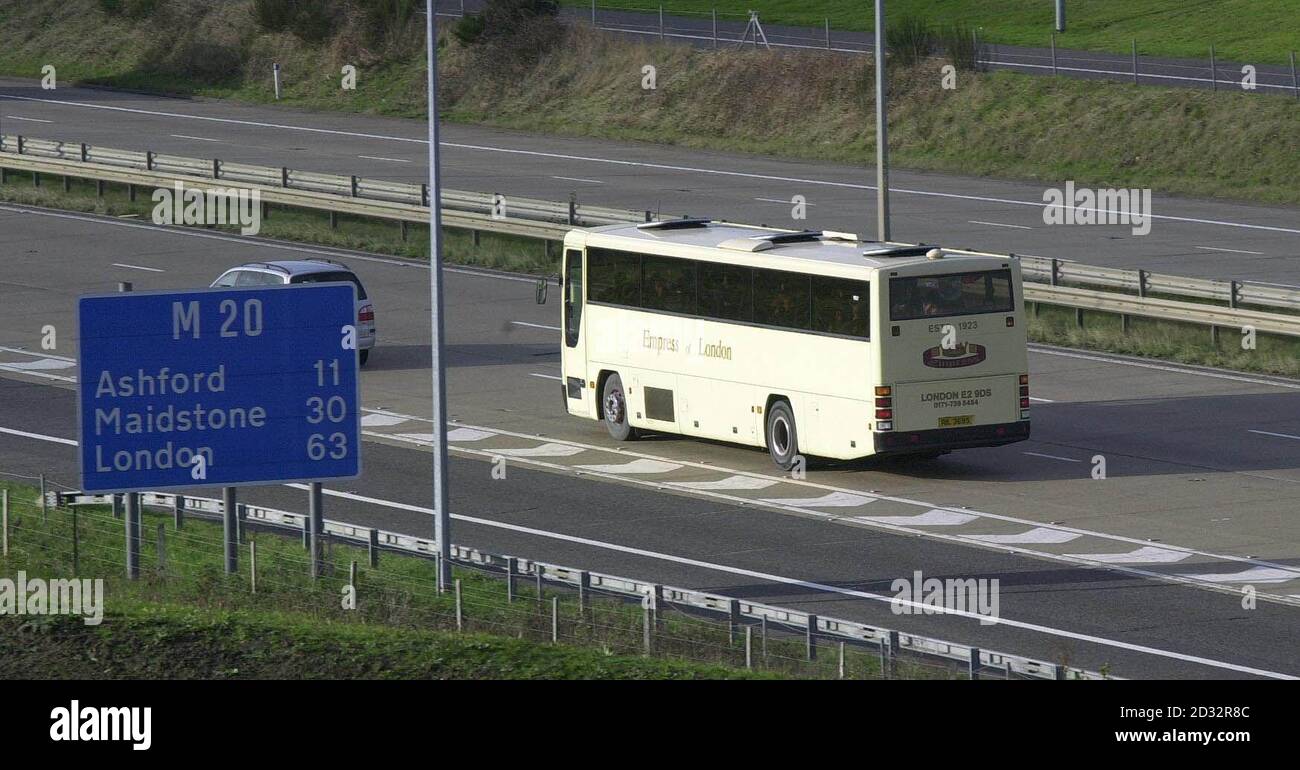 A coach carrying asylum seekers from the Sangatte refugee centre, near Calais, France, joins the London-bound M20 motorway after its short journey under the channel. Stock Photo