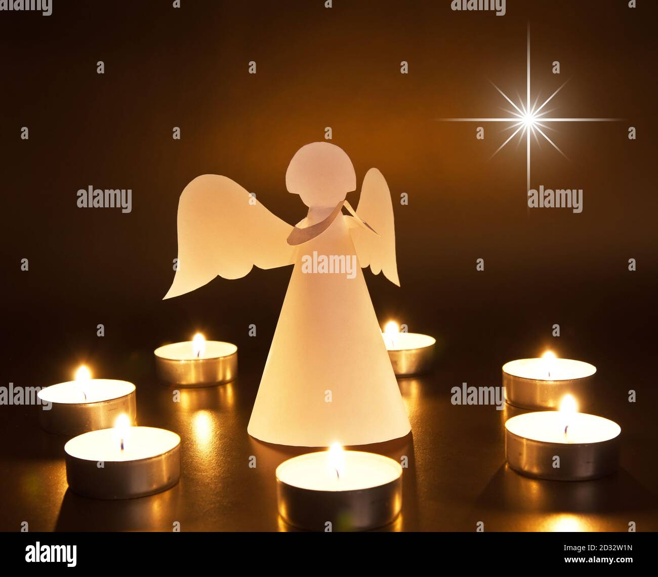 Christmas angel with candles on dark background Stock Photo