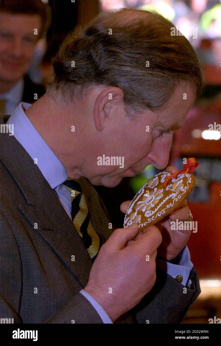 The Prince of Wales samples the aroma of a Biber Valentine Heart, the biscuit cooked to a Swiss recipe and is made out of ground hazelnuts, honey and kirsch. during his visit to Bettys Cafe in Harrogate. Stock Photo
