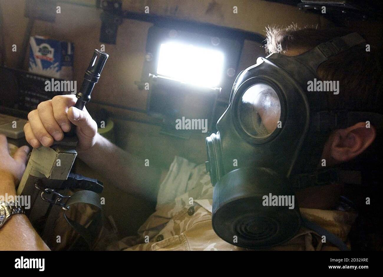 A British trooper wears a respirator as he sits inside a Spartan troop carrier of the 16th Air Assault Brigade during a suspected gas attack on coalition forces gathered close to the Iraqi border. Stock Photo