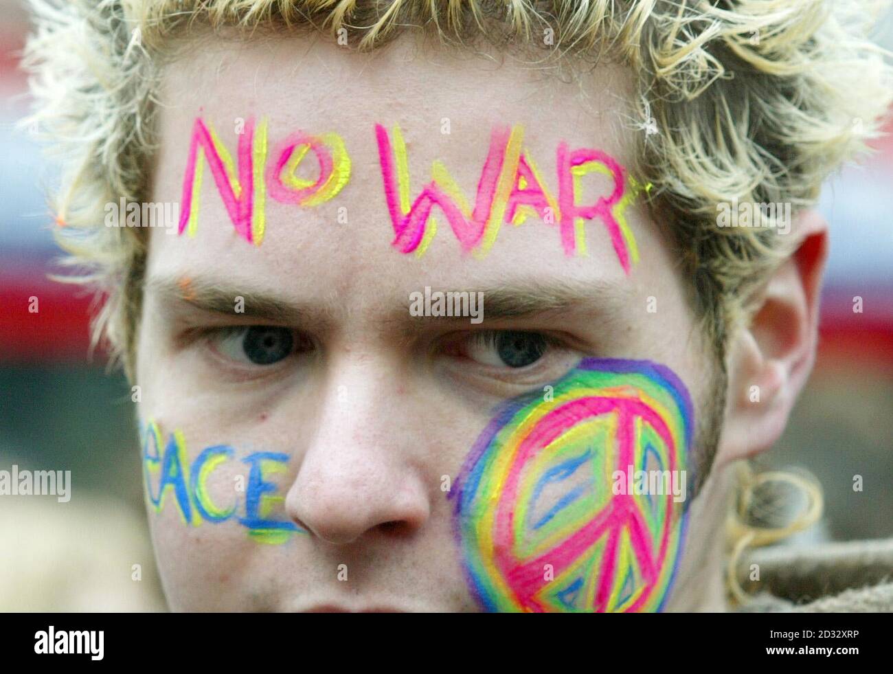 A student with a brightly-painted face joins an anti-war demo through the streets of Manchester, on the day that military action began against Iraq. Stock Photo