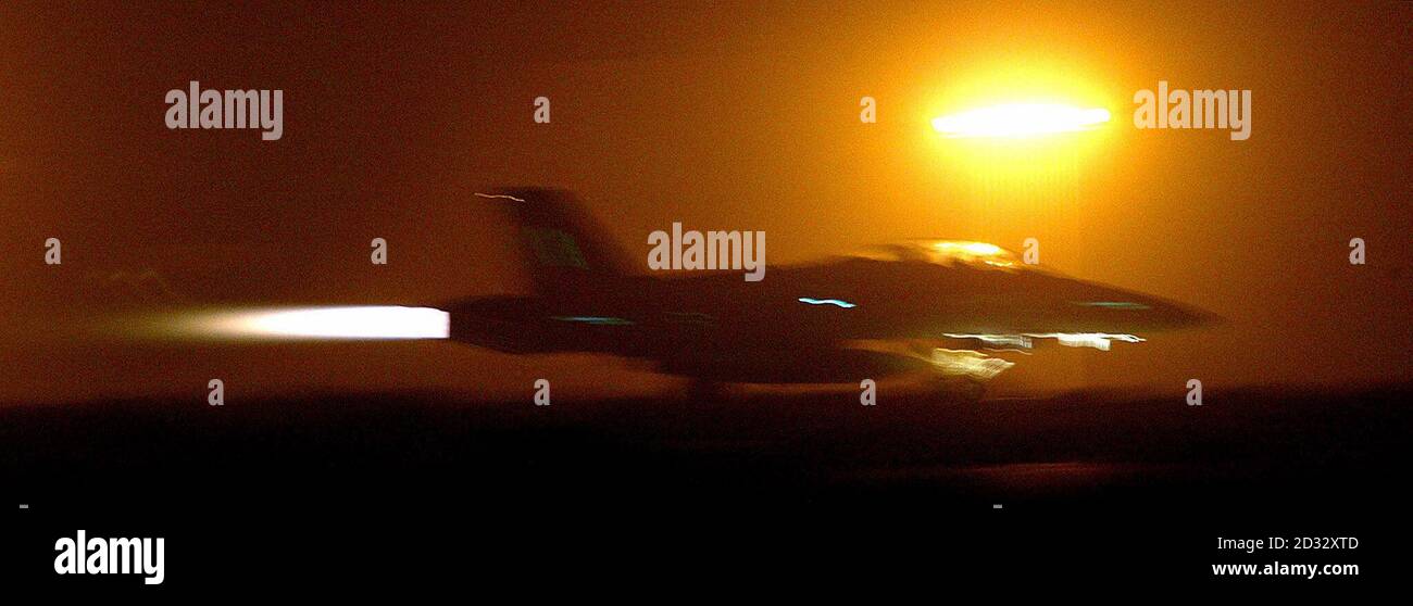 A U.S. Marine F18 roars down the runway to take off from a base in Kuwait towards his mission over Iraq. U.S. and British forces invaded Iraq, crossing the desert border from Kuwait under cover of an intense artillery barrage, as a second air raid pounded targets in Baghdad. Stock Photo