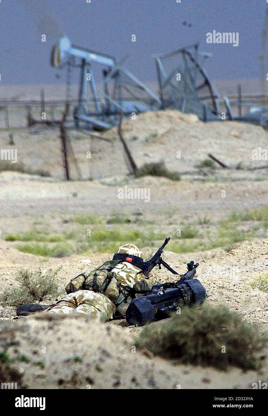 A Household Cavalry regiment sentry keeping watch across the southern Iraq border behind destroyed oil pumps from the last Gulf conflict. Stock Photo