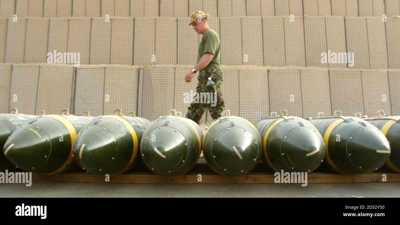 A British Royal Air Force weapons technician Junior Technician Richard Cole walks past a row of freefall bombs stacked at the bomb dump at their base in Kuwait.   * The combined airforces of the U.S and Britain have the capacity to drop as many bombs in one day as were dropped in the whole of the last Gulf war. Stock Photo