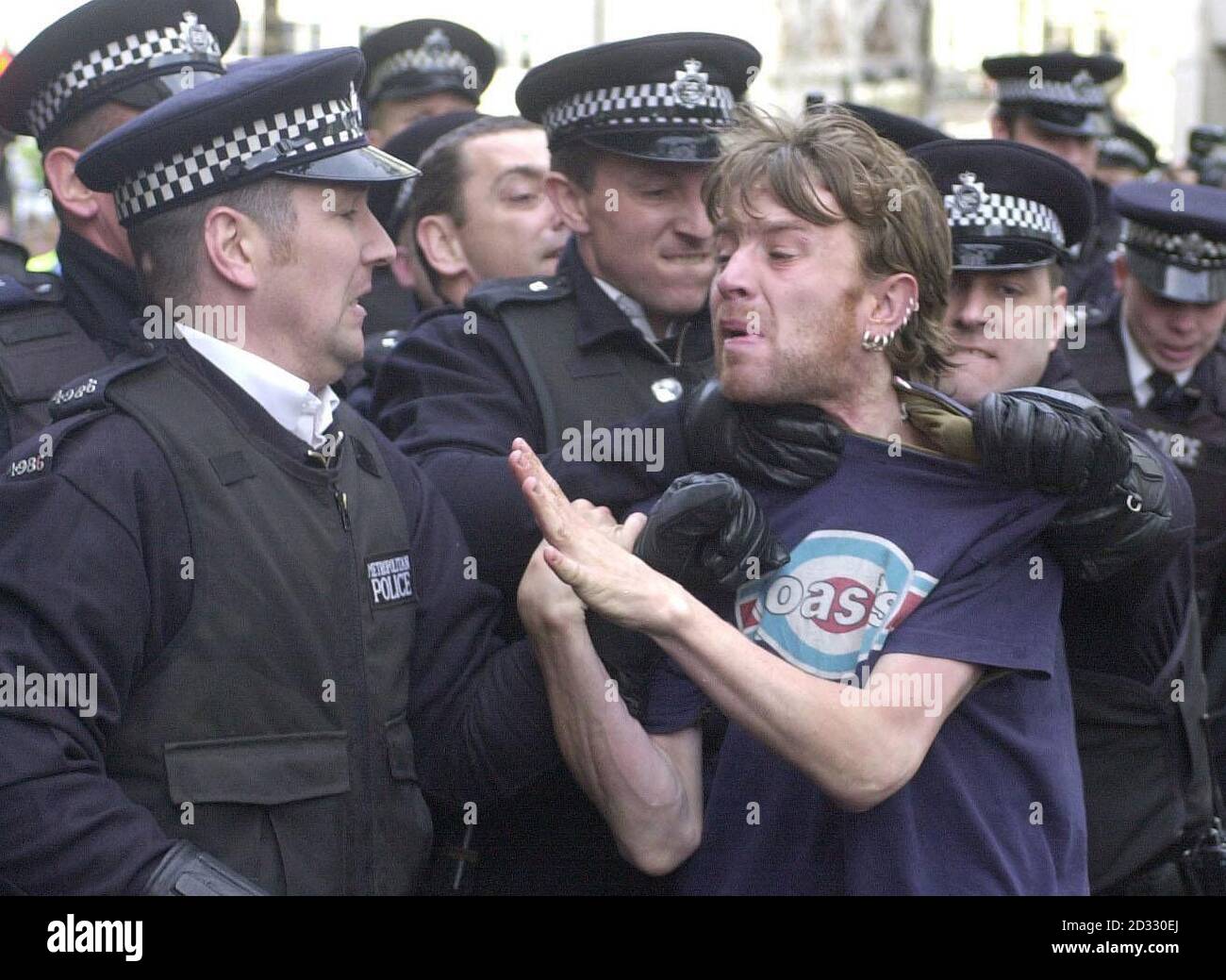 A protester is detained by police during a May Day demonstration in London's Trafalgar Square. Stock Photo