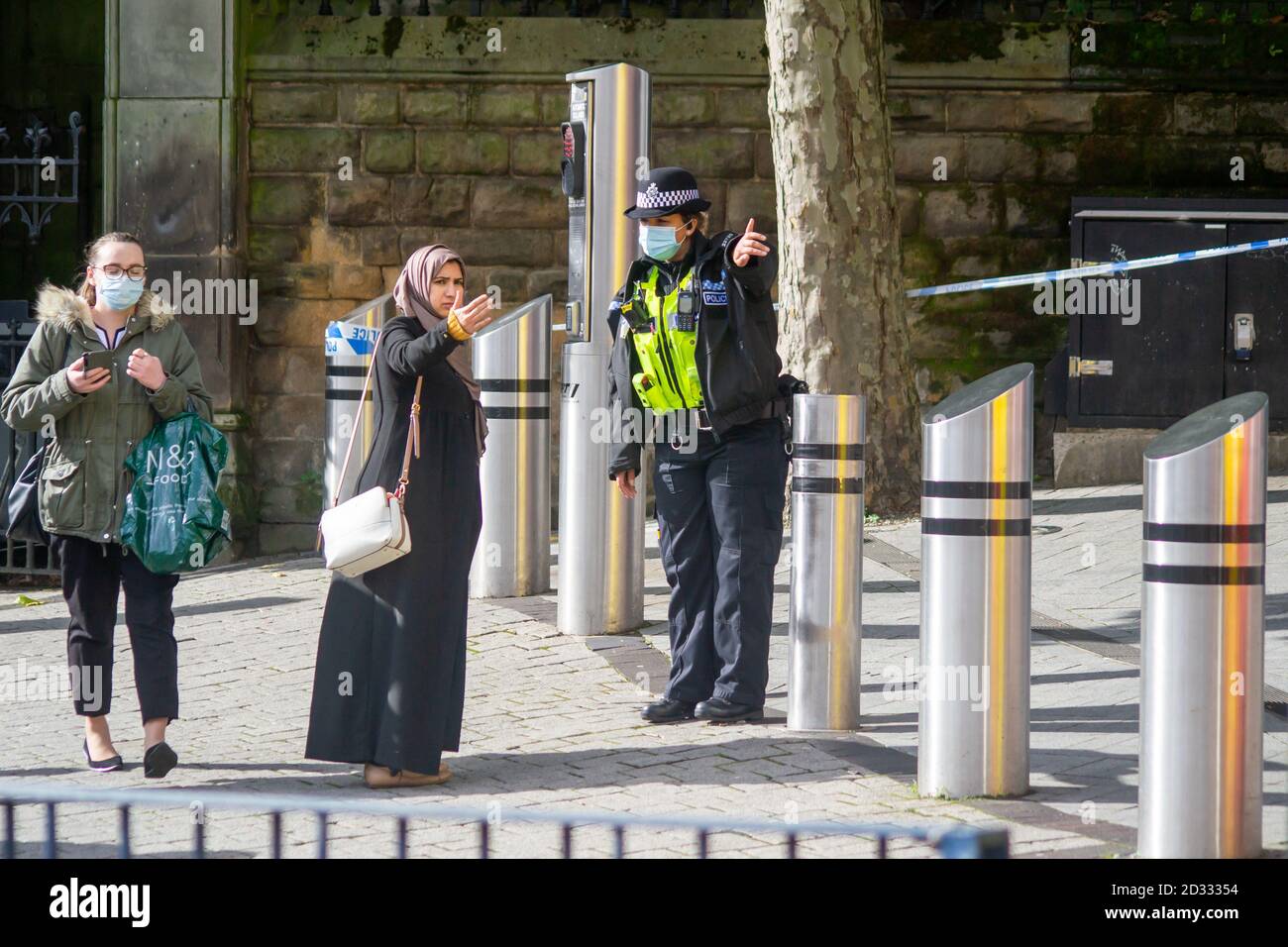 West Midlands female Police constable gives a lady directions around a police cordon following an overnight assault at the Markets in Birmingham Stock Photo
