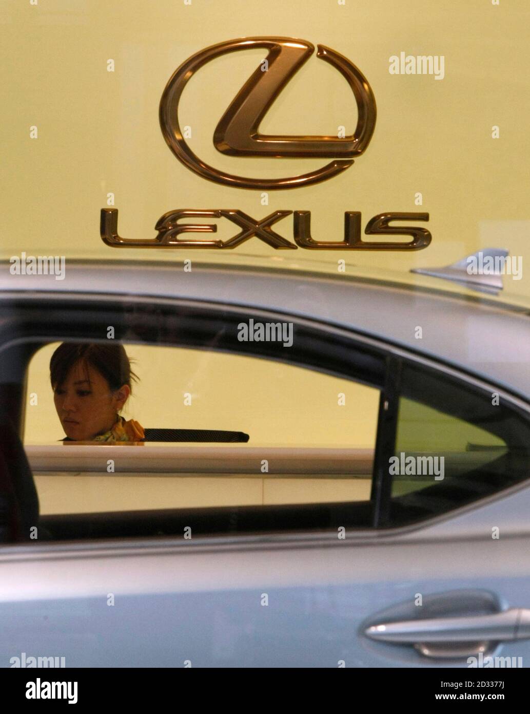 A woman sits in a Toyota Motor Corp's Lexus showroom in Yokohama, south of Tokyo, December 22, 2008. Toyota Motor Corp is set to slash its annual outlook on Monday to a consolidated operating loss of 150 billion yen ($1.67 billion) -- its first such loss ever, the Nikkei business daily reported in its evening edition.  REUTERS/Toru Hanai (JAPAN) Stock Photo