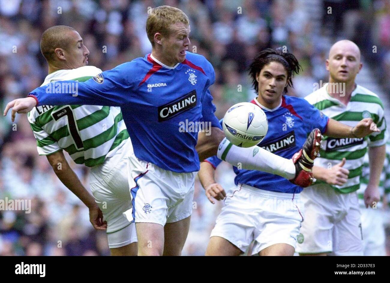 EDITORIAL USE ONLY:  Celtic's Henrik Larsson (left) challenges Rangers' Michael Ball with Mickel Arteta (second right) and John Hartson (right) lookiing on during their Bank of Scotland Premier League match at the Ibrox Stadium, Glasgow. Celtic won 1-0. Stock Photo