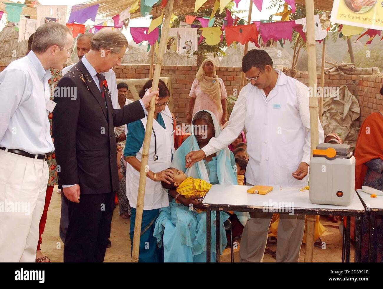 The Prince of Wales watches a child being vaccinated during a visit to Kutail Gamri village on the outskirts of Delhi. There he also saw the work of the Arpana Trust UK, of which he is patron, which attempts to empower poor and low caste women.... ... and has set up daycare services for children and antenatal clinics in the village. Stock Photo