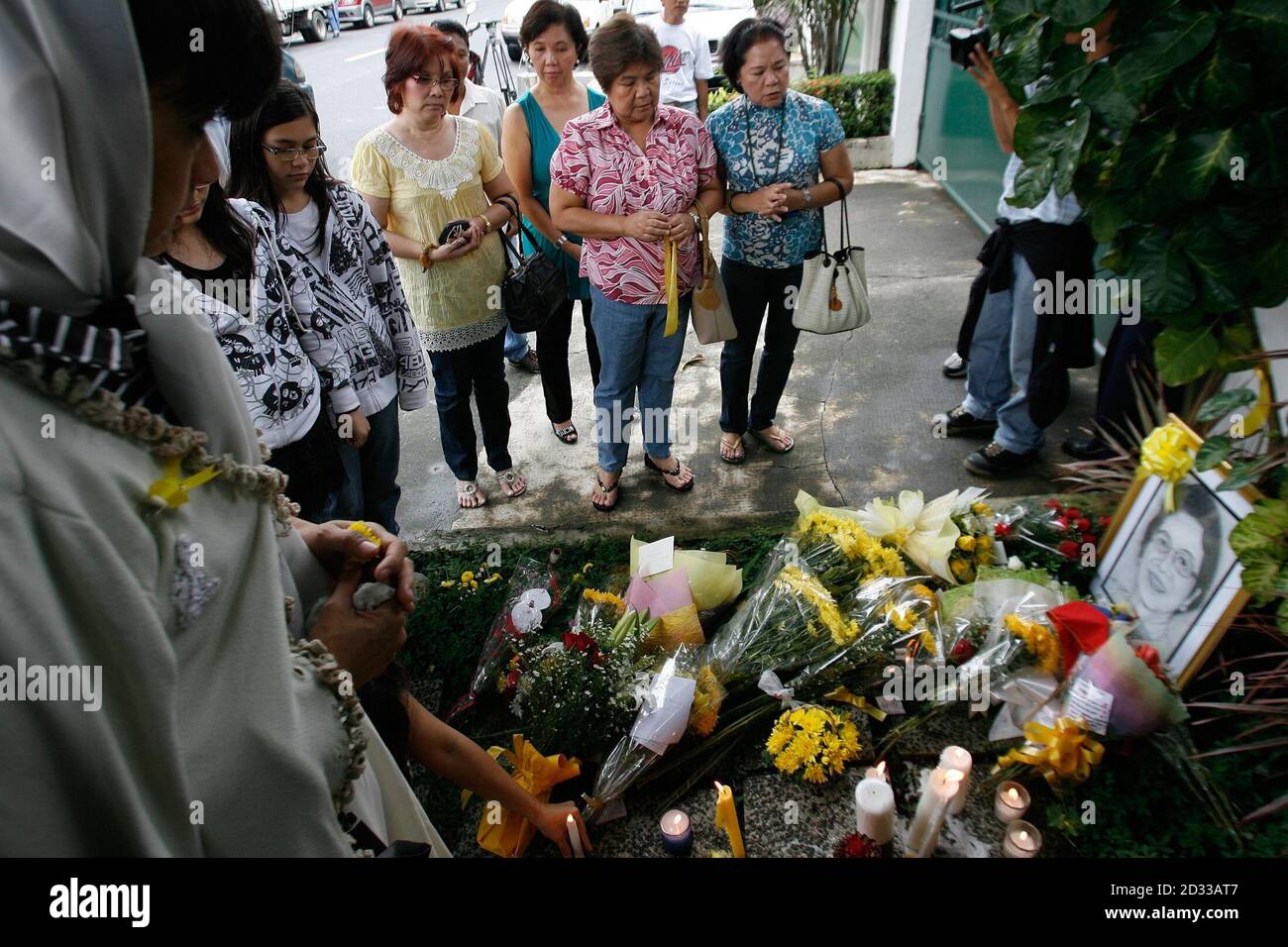 Supporters of the late former Philippine president Corazon Aquino pray in front of Aquino's residence in Manila's suburban Quezon city August 1, 2009. Aquino, a heroine of the 1986 'people power' revolution, has died on Saturday after a 16-month battle against colon cancer. She was 76.   REUTERS/Erik de Castro       (PHILIPPINES POLITICS OBITUARY) Stock Photo