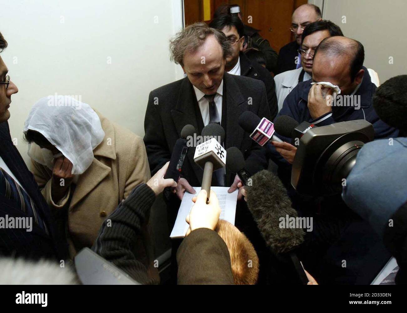 The solicitor (centre) to the parents of murdered teenager Shafilea Ahmed, Iftikhar (right) and Farzana (left) speaks during a press conference in Warrington, where he read 'They wish to confirm once more that they strenuously deny any direct or indirect involvement in their daughter's untimely demise'. Stock Photo