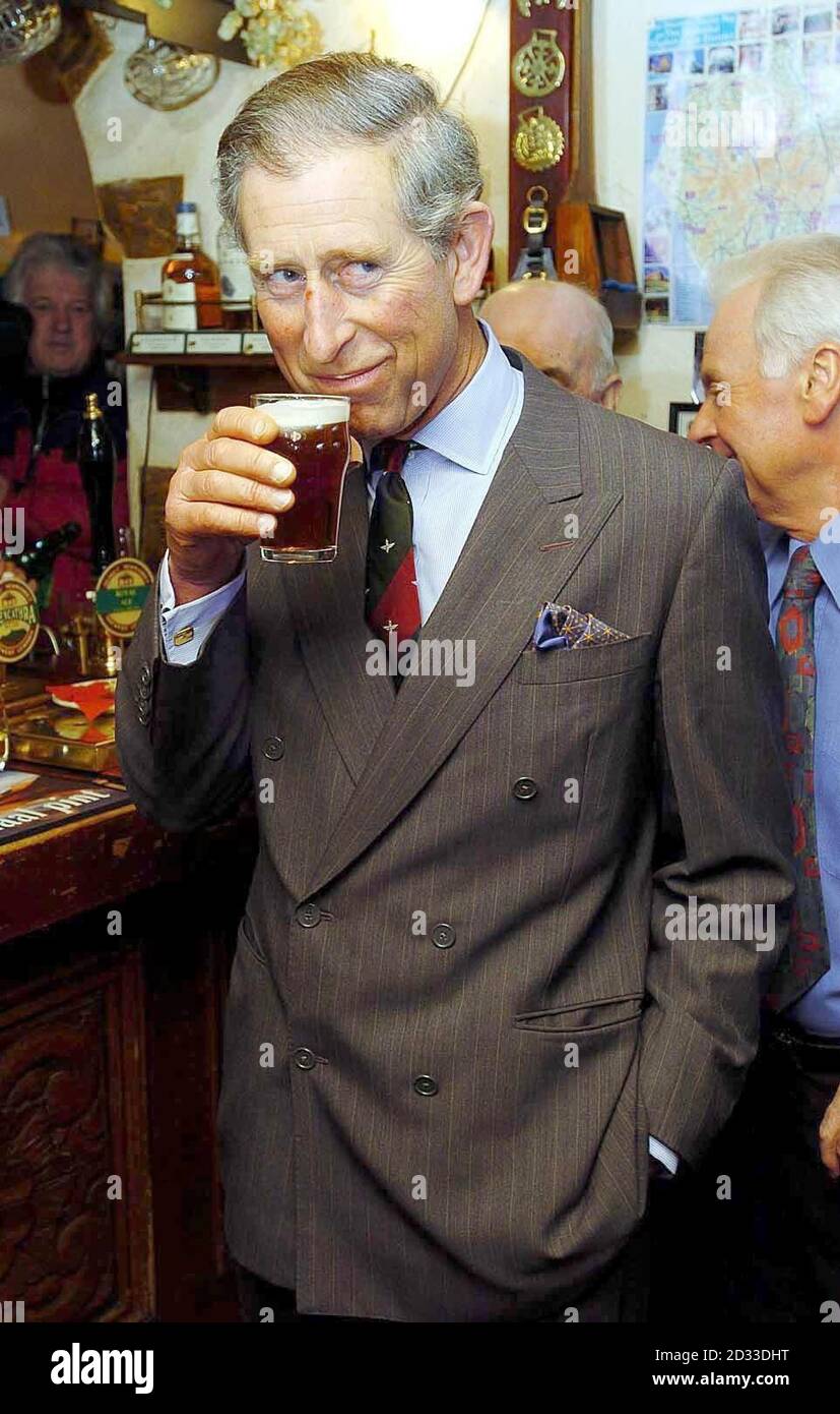 The Prince of Wales samples the locally brewed beer called 'Doris' 90th Birthday' at The Old Crown pub during a visit to Newmarket Village, Hesket, Cumbria. Stock Photo