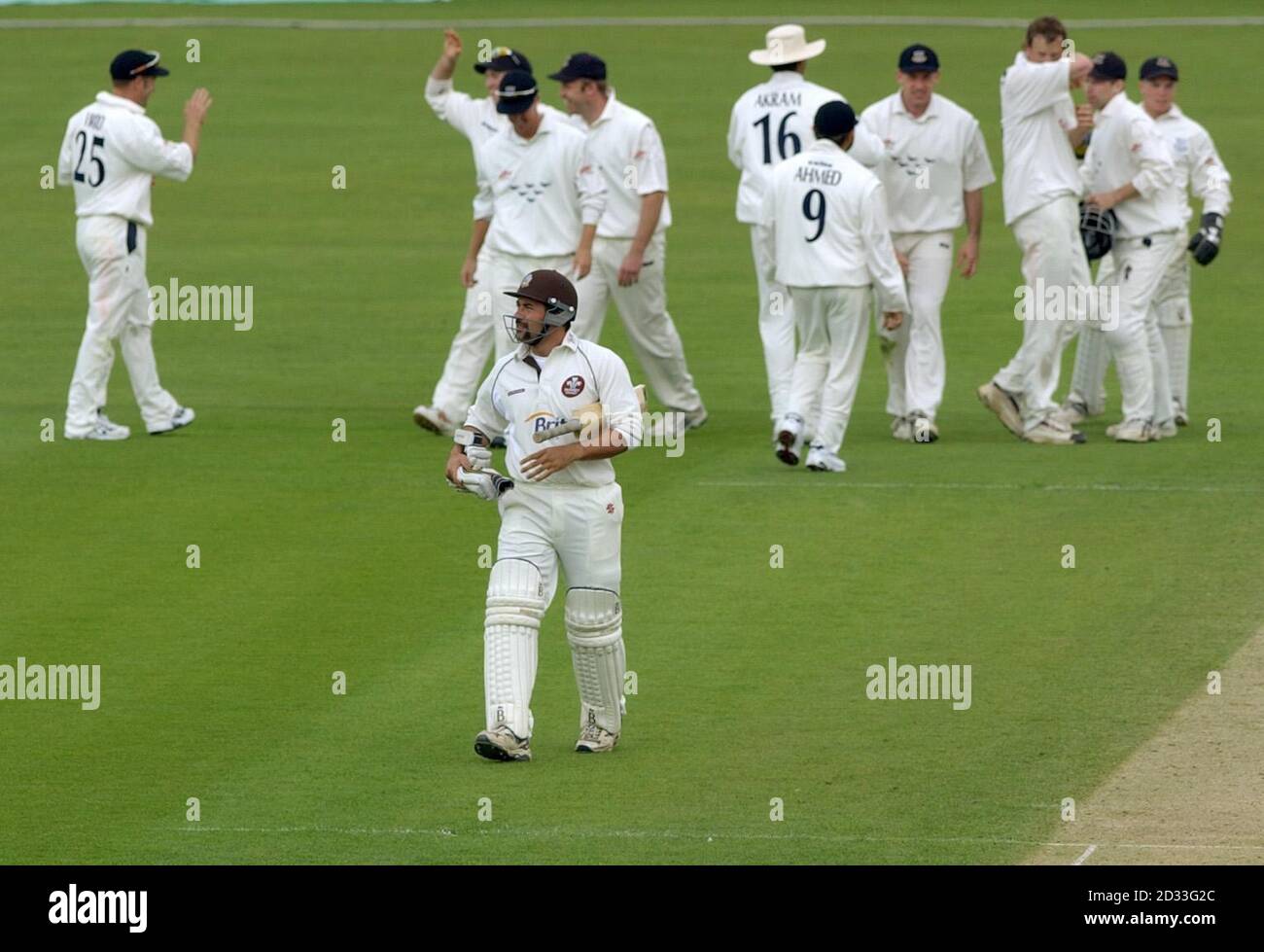 Surrey's Adam Hollioake (centre front) walks back to the pavilion after being caught by Sussex's Tim Ambrose for 4 runs off the bowling of Robin Martin-Jenkins during the first day of their County Championship match at The Oval, London.  Surrey were 84-5 at lunch. Stock Photo