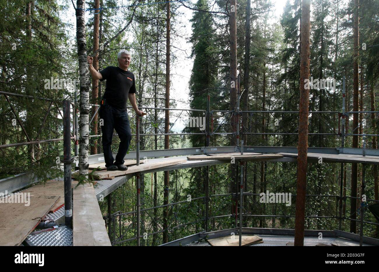 Treehotel co-founder Kent Lindvall stands on the scaffolding around The Nest on the construction site of Treehotel in the Swedish village of Harads, July 5, 2010. A lofty new hotel concept is set to open in a remote village in northern Sweden, which aims to elevate the simple treehouse into a world-class destination for design-conscious travellers. Treehotel, located in Harads about 60 km south of the Arctic Circle, will consist of four rooms when it opens on July 17th: The Cabin, The Blue Cone, The Nest and The Mirrorcube. Picture taken July 5, 2010.     To match Reuters Life! SWEDEN-TREEHOTE Stock Photo