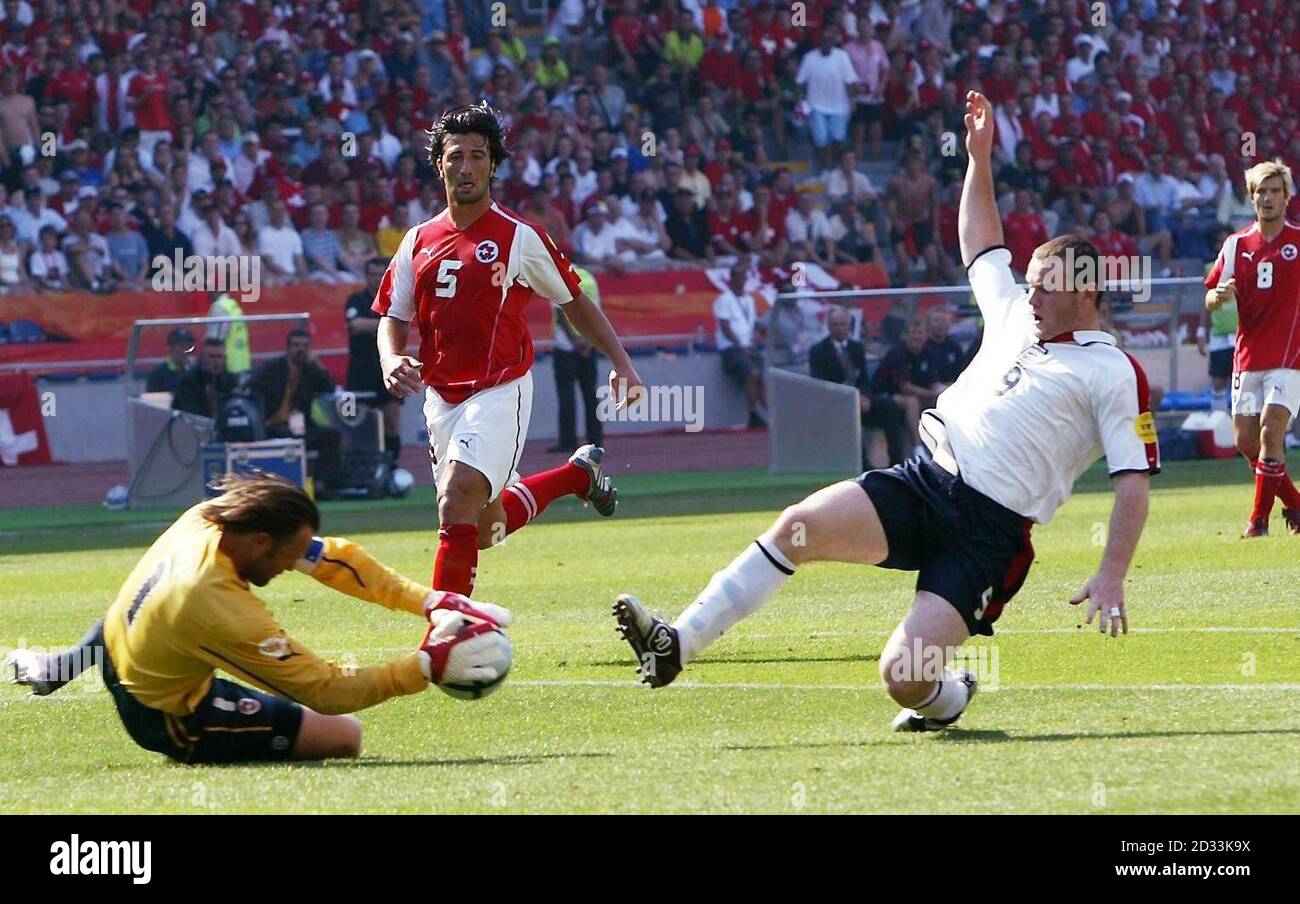England's Wayne Rooney (right) challenges Switzerland goalkeeper Jorg Stiel, for which he later received a yellow card, during the Euro 2004, first round, Group B match at the Cidade de Coimbra, Portugal. EDITORIAL USE ONLY, NO MOBILE PHONE OR PDA USE. INTERNET USE ONLY ON UEFA AUTHORISED SITES AND THEN, NO MORE THAN 10 PHOTOGRAPHS PER HALF OF NORMAL PLAYING TIME AND FIVE PHOTOGRAPHS PER HALF OF EXTRA TIME CAN BE PUBLISHED VIA THE INTERNET WITH AN INTERVAL OF AT LEAST ONE MINUTE BETWEEN THE POSTING OF EACH SUCH PHOTOGRAPH. Stock Photo