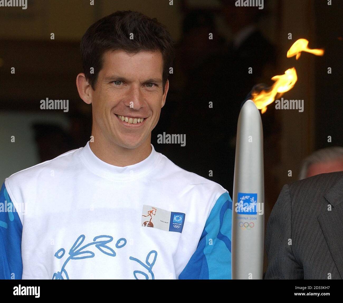 Tim Henman holds the Olympic torch after receiving it from Sir Roger Bannister outside the Centre Court at the Lawn Tennis Championships in Wimbledon. Henman later passed the flame to former champion Virginia Wade for the journey into central London. Stock Photo