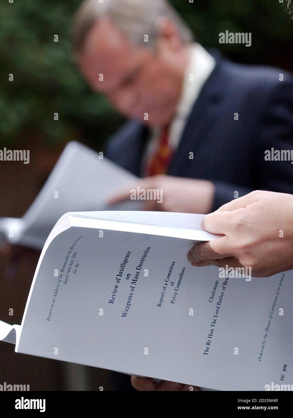 Reporters in Downing Street read copies of Lord Butler's report into intelligence failings in the run-up to war in Iraq following its publication.  Lord Butler was commissioned in February to look into the gap between the intelligence community's pre-war claims that Iraqi dictator Saddam Hussein had illicit arsenals of weapons of mass destruction and the failure of the Iraq Survey Group to find any trace of such stockpiles. Stock Photo