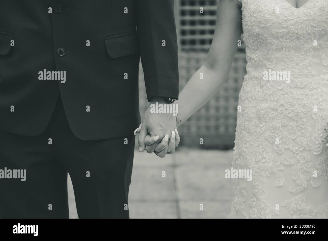 Wedding couple holding hands close up in black and white Stock Photo