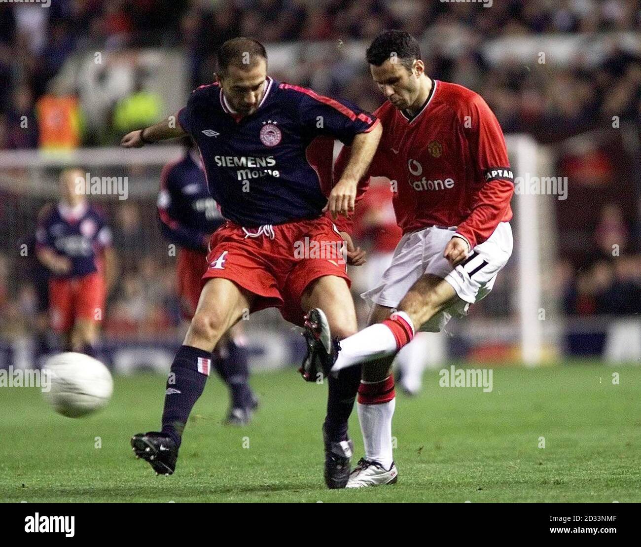 Manchester United's Ryan Giggs (right)gets his cross in past Olympiakos  Dimitrios Mavrogenidis during the UEFA Champions League Group G match at  Old Trafford, Manchester. THIS PICTURE CAN ONLY BE USED WITHIN THE