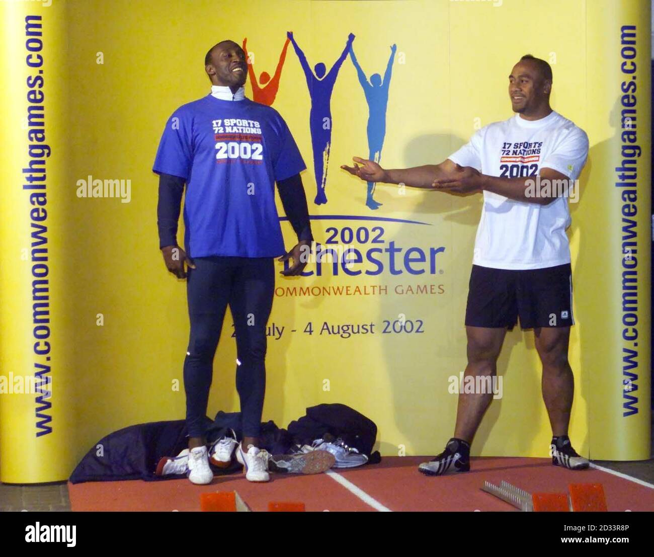 Linford Christie and Jonah Lomu (R) pose in their Commonwealth Games promotional T-shirts at The Printworks, Manchester. New Zealand All Blacks' Lomu took on former Olympic gold medalist Christie in a head-to-head sprint, what Christie won. * as part of the countdown towards the 2002 Commonwealth Games. Stock Photo