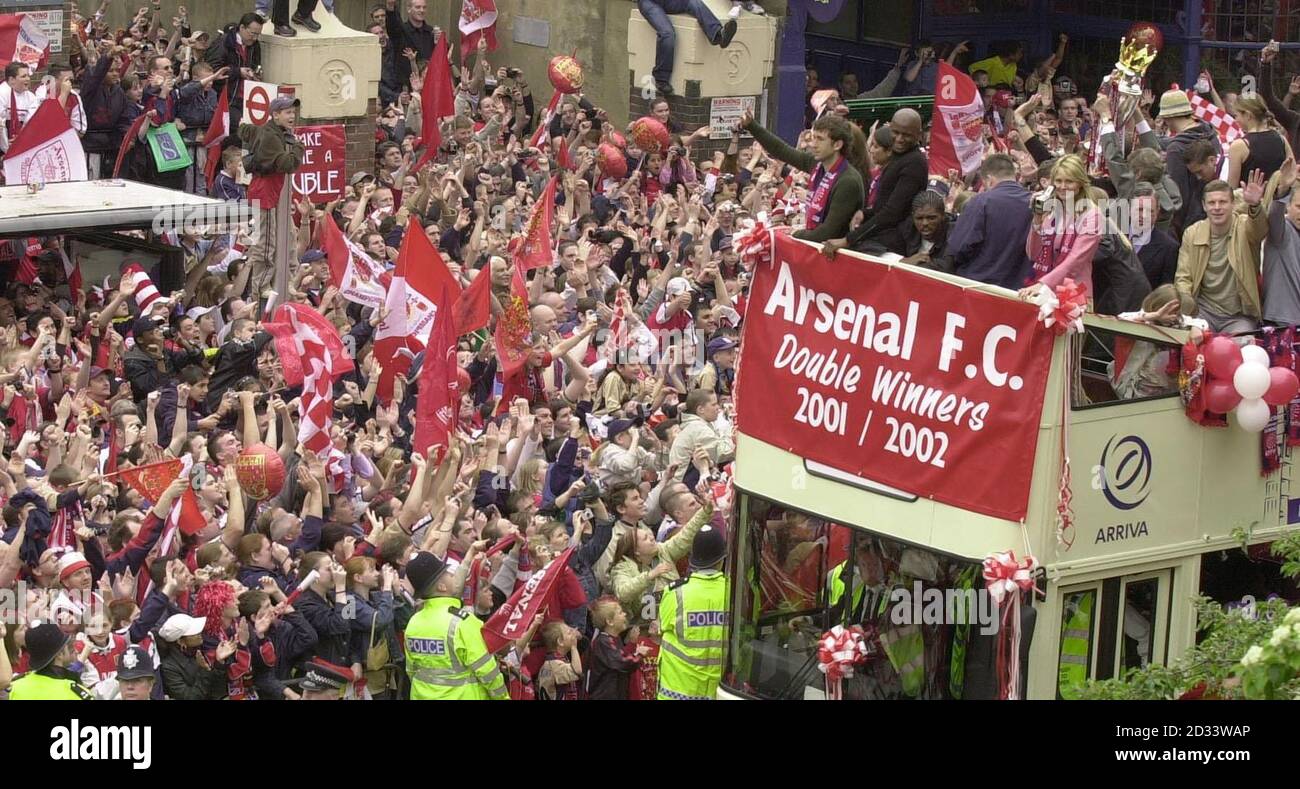 Arsenal's manager Arsene Wenger holds the Premiership Trophy and FA Cup, to thousands of supporters. The club's squad went to Islington Town hall, to a civic reception where they showed off the two trophies which were won in the last week. Stock Photo