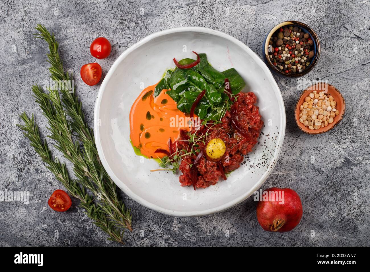 Beef steak tartare with egg yolk, onion and herbs. French cuisine. The