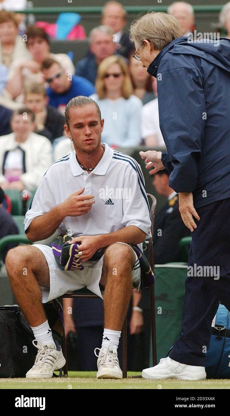 EDITORIAL USE ONLY, NO COMMERCIAL USE. Xavier Malisse of Belgium speaks with trainer Bill Norris after experiencing chest pains during his semi-final match against the Argentinian David Nalbandian on Court One at Wimbledon. Malisse contravertialy left the court for ten minutes to receive medical attention after losing the first set tie break. Stock Photo