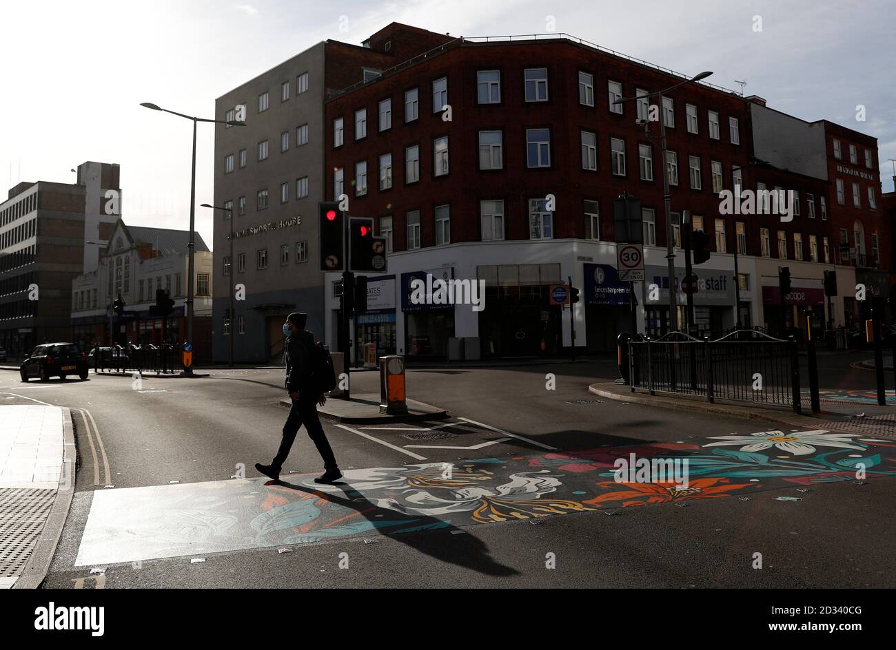 Leicester, Leicestershire, UK. 7th October 2020. A man walks on pedestrian crossing redesigned with colourful coverings 100 days since the UKÕs first local coronavirus pandemic lockdown was announced in the city. Credit Darren Staples/Alamy Live News. Stock Photo